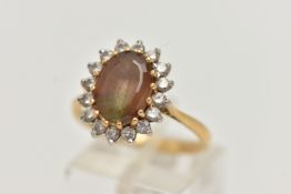 AN 18CT GOLD SMOKY QUARTZ AND DIAMOND CLUSTER RING, the oval smoky quartz within a brilliant cut