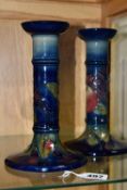 A PAIR OF MODERN MOORCROFT POTTERY CANDLESTICKS DECORATED WITH FINCHES AND FRUIT, painted and