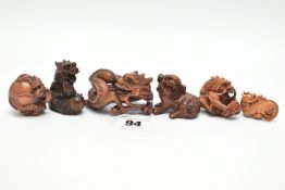 FOUR 20TH CENTURY CARVED TREEN NETSUKE AND TWO OKIMONO, all in the form of dragons, all with inset