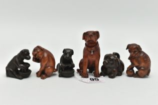 FOUR 20TH CENTURY CARVED TREEN NETSUKE AND TWO OKIMONO, all in the form of dogs, five with inset