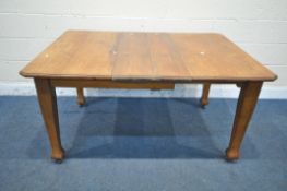 AN ARTS AND CRAFTS OAK WIND OUT DINING TABLE, with two additional leaves and one winding handle,