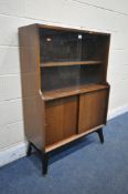 A MID CENTURY TOLA AND BLACK BOOKCASE, with two glazed sliding doors above two wooden sliding doors,