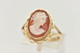 A 9CT GOLD CAMEO RING, carved shell cameo, collet set within a fine rope twist and scallop surround,