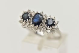 AN 18CT WHITE GOLD SAPPHIRE AND DIAMOND RING, designed as a central oval sapphire flanked by