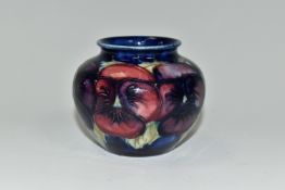 A MOORCROFT POTTERY 'BLUE PANSY' PATTERN SMALL BULBOUS VASE, purple and blue pansies on a dark