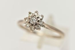 A DIAMOND CLUSTER RING, a round brilliant cut diamond, prong set with a surround of eight single cut