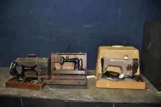 THREE VINTAGE SEWING MACHINES IN CASES comprising of a manual Singer, an electric Singer (untested)