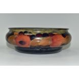 A MOORCROFT POTTERY POMEGRANATE BOWL, decorated with pomegranates on a mottled blue ground,