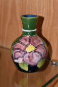 A MOORCROFT POTTERY BUD VASE, in 'Clematis' pattern on a green-blue ground, impressed marks to base,