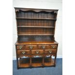 IN THE MANNER OF TITCHMARSH AND GOODWIN, A SOLID OAK DRESSER, the top being a three tier plate rack,