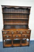IN THE MANNER OF TITCHMARSH AND GOODWIN, A SOLID OAK DRESSER, the top being a three tier plate rack,
