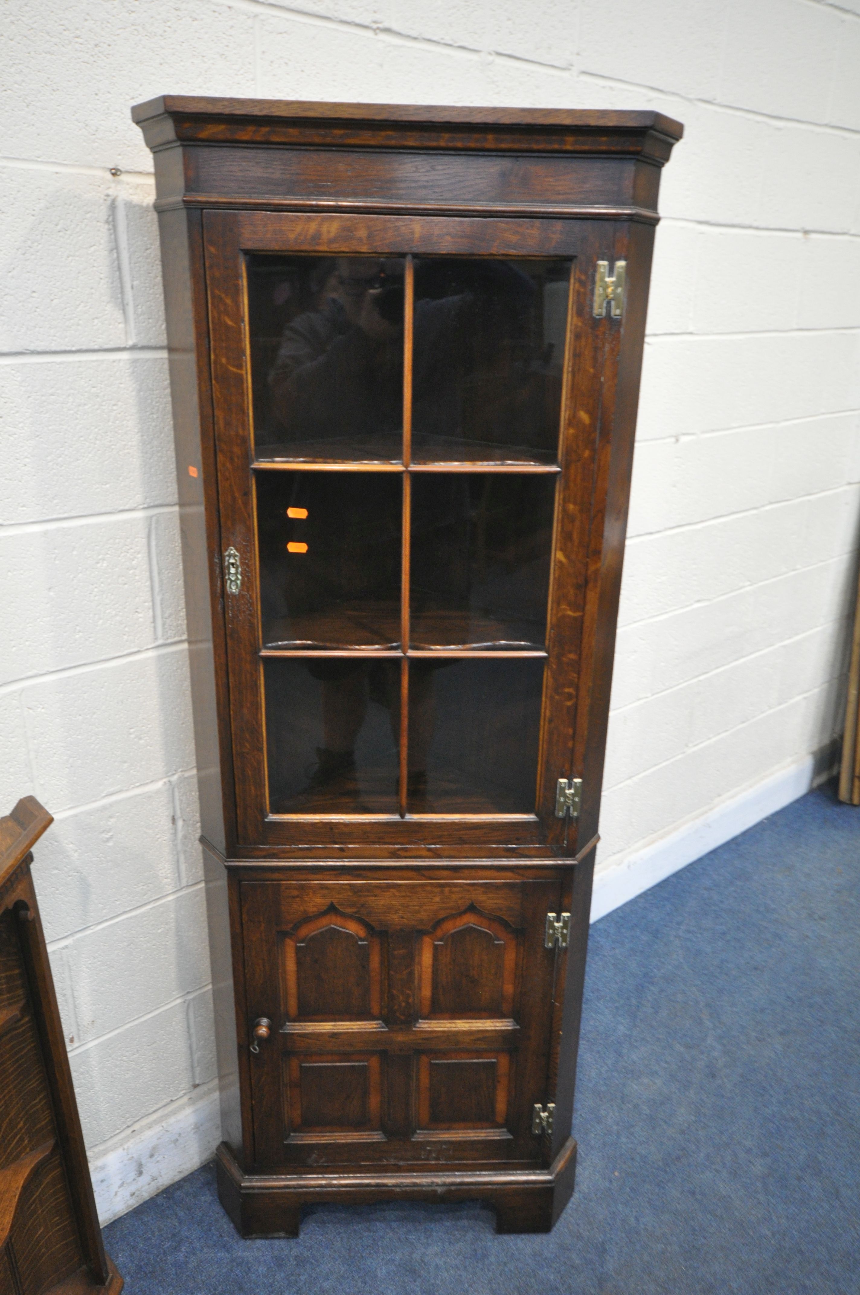 IN THE MANNER OF TITCHMARSH AND GOODWIN, A SOLID OAK CORNER CUPBOARD, with a glazed door, above a - Image 2 of 4