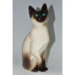 A WINSTANLEY POTTERY FIGURE OF A SIAMESE CAT, with bright blue glass eyes, signed 'Winstanley,