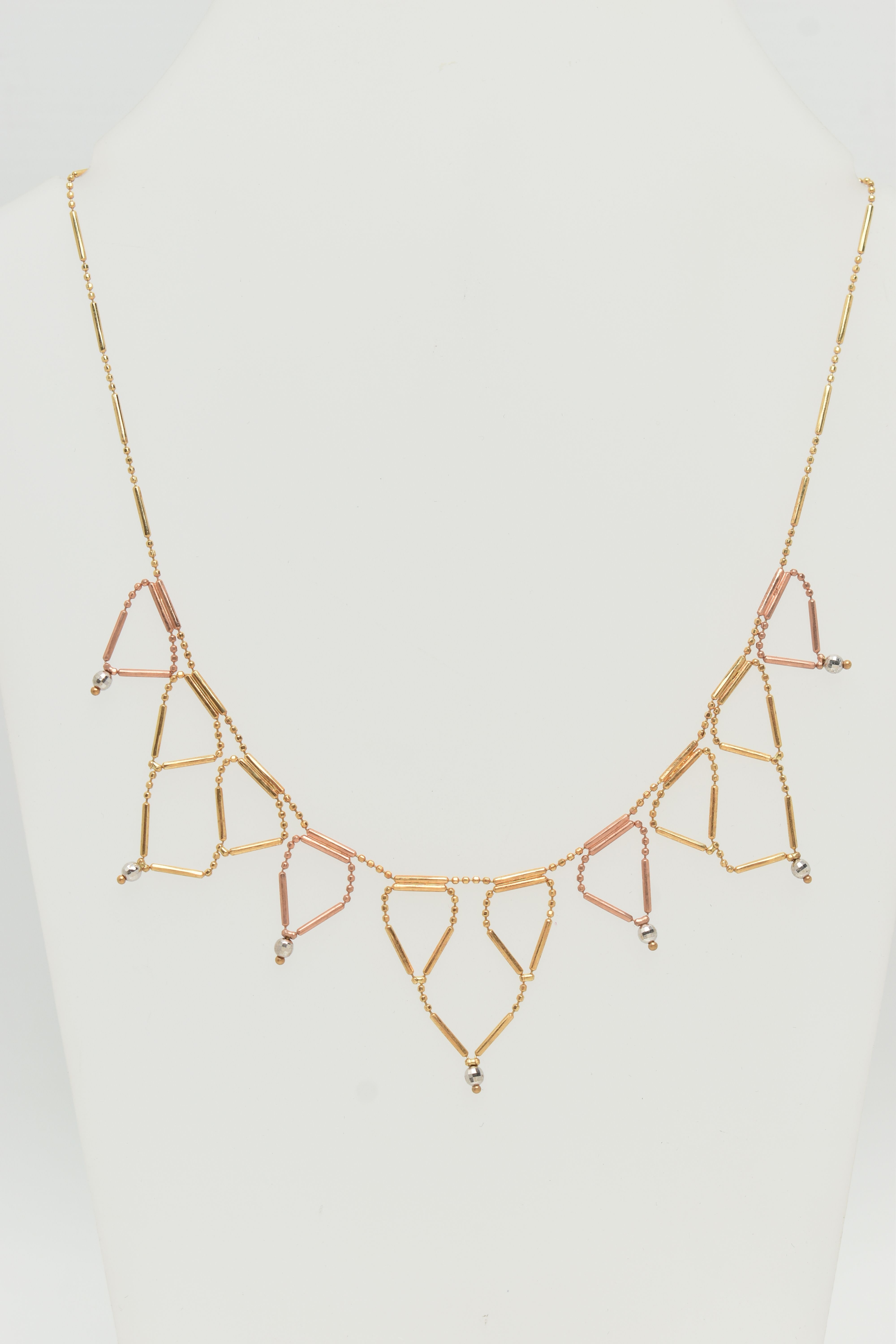 A BI-COLOUR FRINGE NECKLACE, the faceted and tubular design chain suspending triangular fringe drops