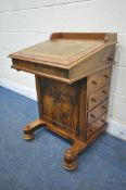 A VICTORIAN WALNUT DAVENPORT, with a raised back, the hinged lid with a tanned and tooled leather