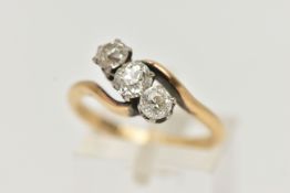 A YELLOW METAL THREE STONE DIAMOND RING, cross over design, set with three old cut diamonds,