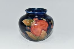 A MOORCROFT POTTERY POMEGRANATE VASE, of squat form, tube lined in Pomegranate pattern on a deep