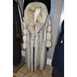 TWO LADIES LONG FUR COATS, comprising a cream and brown tipped Artic fox fur coat with pale grey