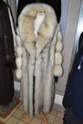 TWO LADIES LONG FUR COATS, comprising a cream and brown tipped Artic fox fur coat with pale grey