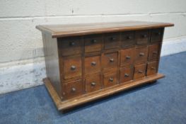 A REPRODUCTION HARDWOOD TABLE TOP APOTHECARY CHEST, fitted with eighteen drawers, on bracket feet,