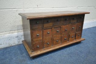 A REPRODUCTION HARDWOOD TABLE TOP APOTHECARY CHEST, fitted with eighteen drawers, on bracket feet,