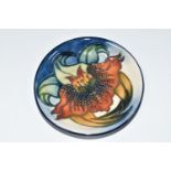 A MOORCROFT POTTERY TRINKET DISH, in 'Anna Lily' pattern on a graduated blue - cream ground,