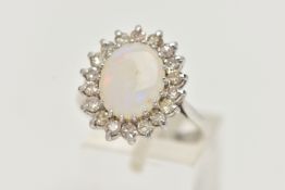 AN OPAL AND DIAMOND CLUSTER RING, designed as a central oval opal cabochon within a single cut