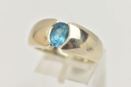 A 9CT GOLD TOPAZ RING, oval cut blue topaz half bezel set, set in a wide tapered white gold band,
