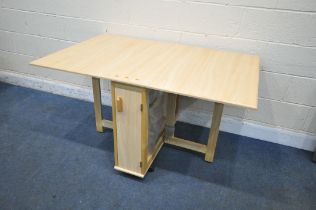 A MODEN BEECH EFFECT DROP LEAF DINING TABLE, with a single door enclosing four bagged fold away
