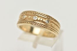 A 9CT GOLD BAND RING, a yellow gold tapered band with rope detail, set with three single cut