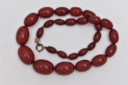 A BAKELITE BEADED NECKLACE, graduated oval cherry amber beads, twenty seven beads in total,