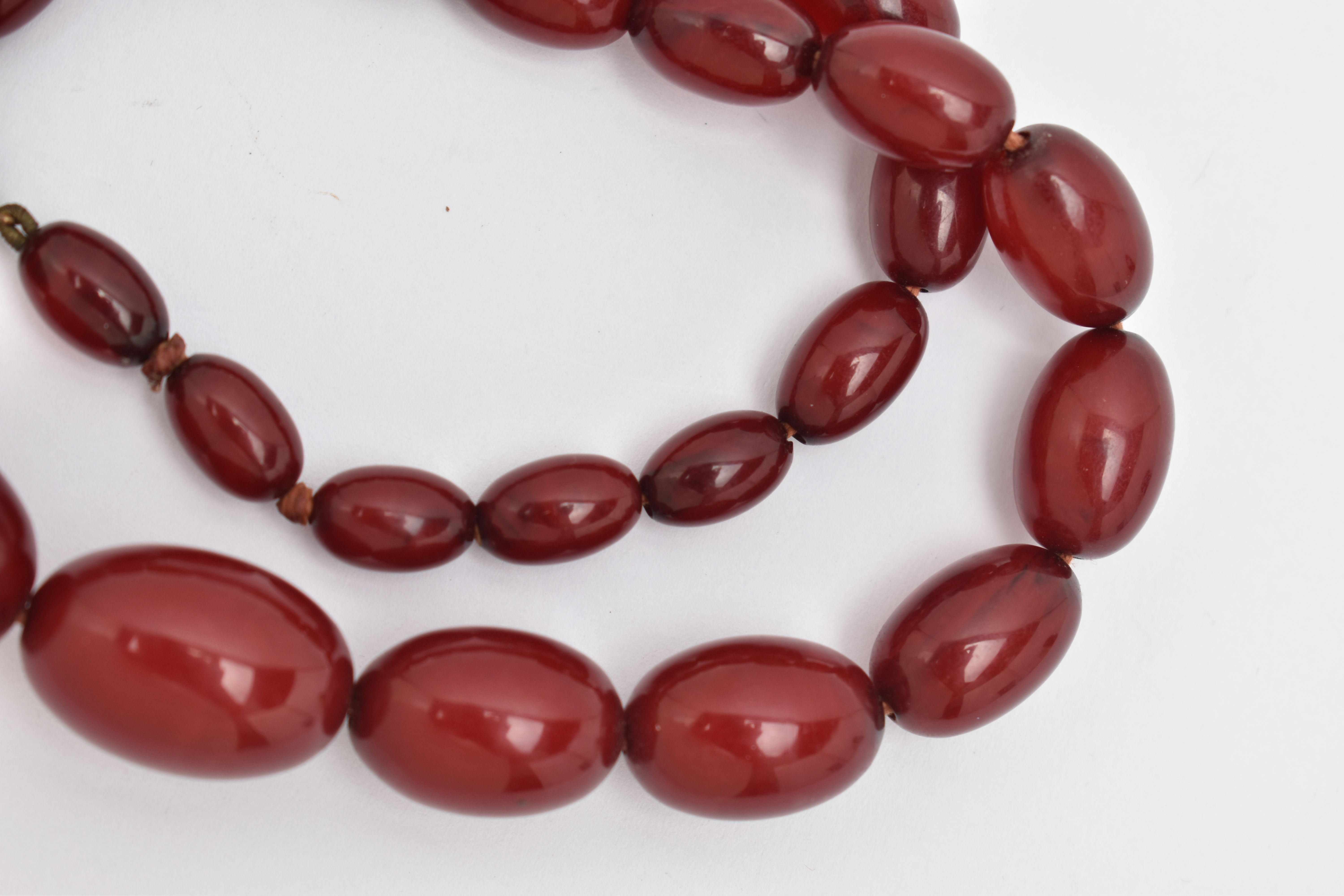 A BAKELITE BEADED NECKLACE, graduated oval cherry amber beads, twenty seven beads in total, - Image 3 of 4