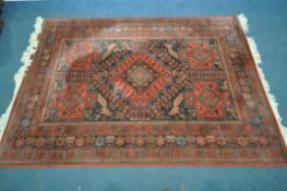 A RED GROUND LOUIS DE POORTERE MOSSOUL WOOLEN RUG, with geometric patterns to central field, and a