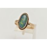 A YELLOW METAL OPAL TRIPLET RING, of an oval design, collet set opal triplet, to a scroll surround