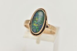 A YELLOW METAL OPAL TRIPLET RING, of an oval design, collet set opal triplet, to a scroll surround