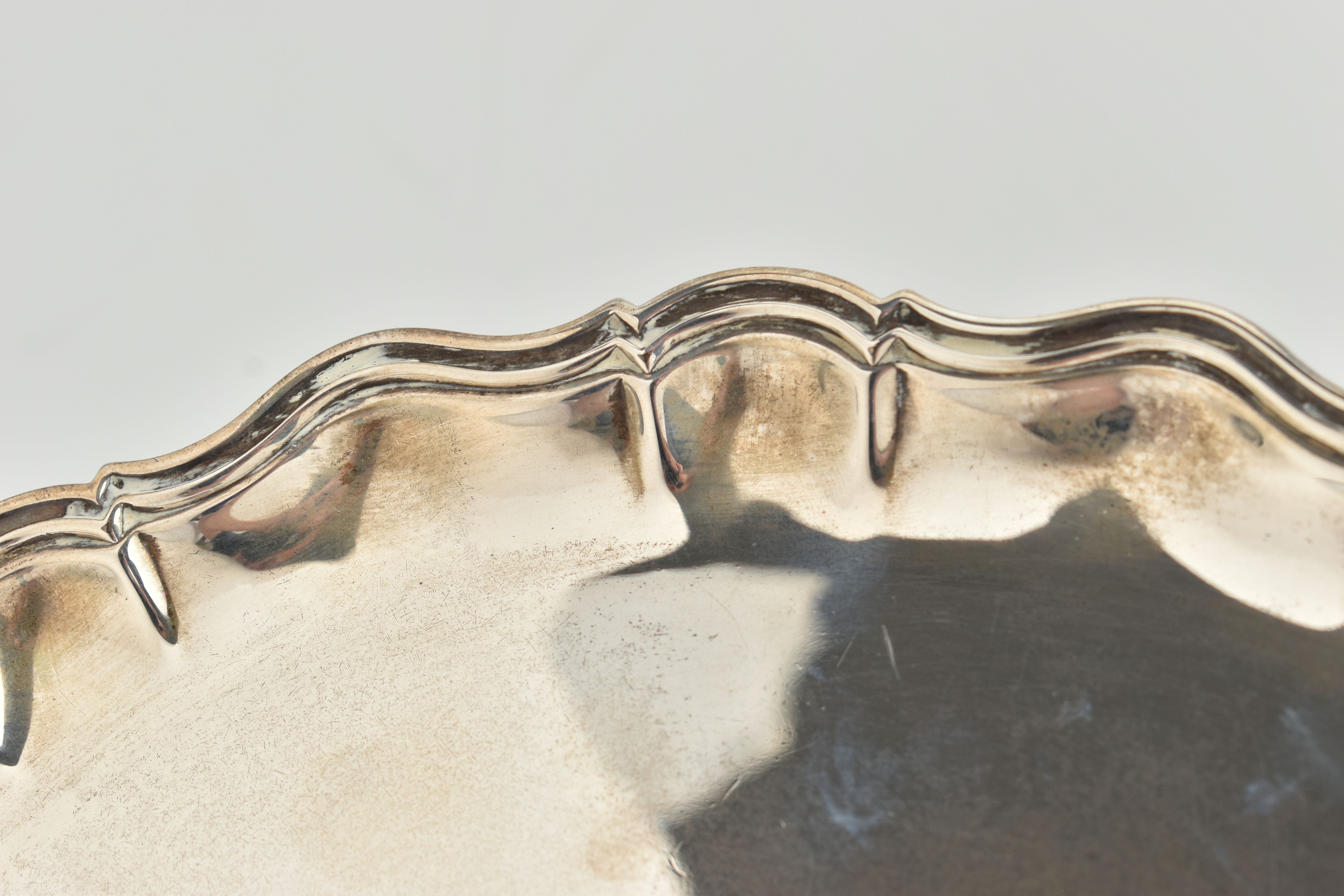 AN EDWARDIAN SILVER SALVER, polished round wavy form, raised on three scroll feet, hallmarked 'James - Image 2 of 5