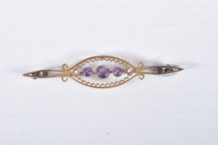 AN EARLY 20TH CENTURY BROOCH, yellow metal open work brooch set with three circular cut amethysts