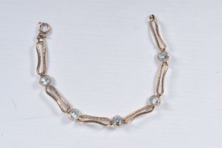 AN AQUAMARINE BRACELET, five oval cut aquamarines bezel set in yellow metal interspaced between