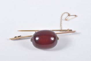 A CHERRY BAKELITE BEAD BROOCH, a large single, oval bead measuring approximately length 28.1mm x