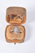 A YELLOW METAL DIAMOND RING, rhombus shape set with eleven old cut diamonds and one round