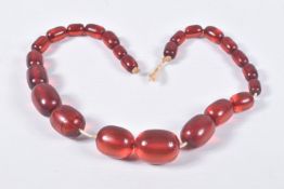 A SINGLE STRAND OF GRADUATED RED PLASTIC BEADS, twenty four oval red beads, largest measuring 29.1mm