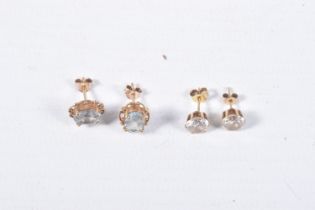 TWO PAIRS OF EAR STUDS, the first designed as an oval blue topaz within a four claw setting with a