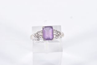 A 9CT WHITE GOLD AMETHYST AND SPINEL RING, set with a rectangular cut amethyst, four claw set,