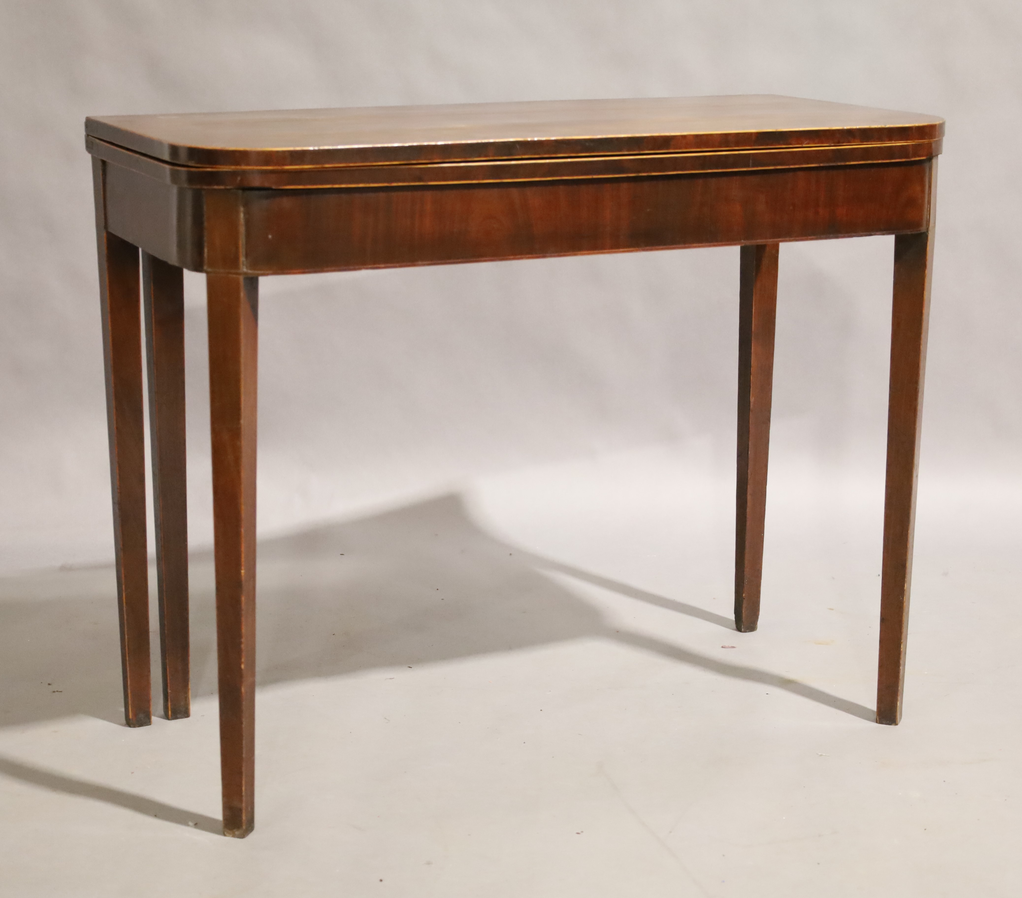 A George III mahogany fold over tea table, circa 1780, boxwood strung, raised on square tapering - Image 2 of 3