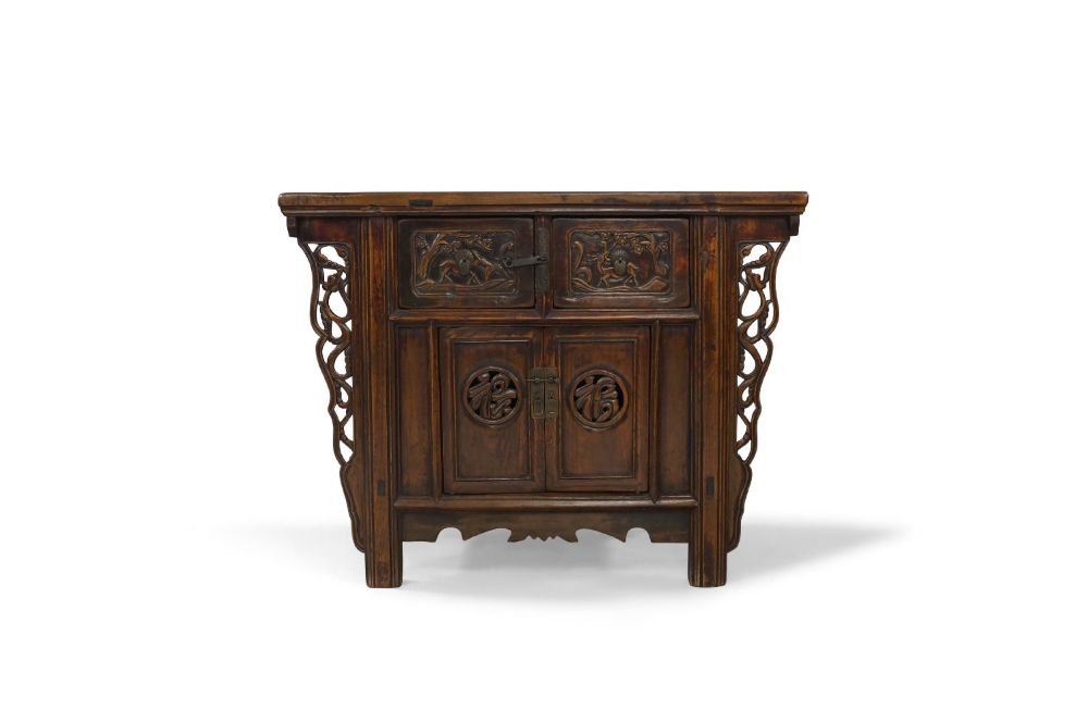A Chinese elm side cabinet, early 20th century, the rectangular top above two drawers, carved with