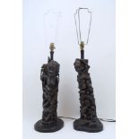 A pair of African carved hardwood lamps, 20th century, each a 'Tree of Life' design, atop a shaped