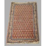 A small Persian Malayer rug, 20th century, repeating paisley motifs, on a red ground, contained by