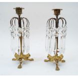 A pair of Regency style brass candlestick lustres with facetted glass drops, first half 20th