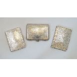 Three silver card cases, comprising: a Victorian example with chased leaf and scrolling foliate