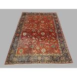 A Persian Sarouk carpet, the central field with floral and zoomorphic motifs, on a rouge ground,